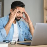Man sitting at his desk working and feeling burnt out
