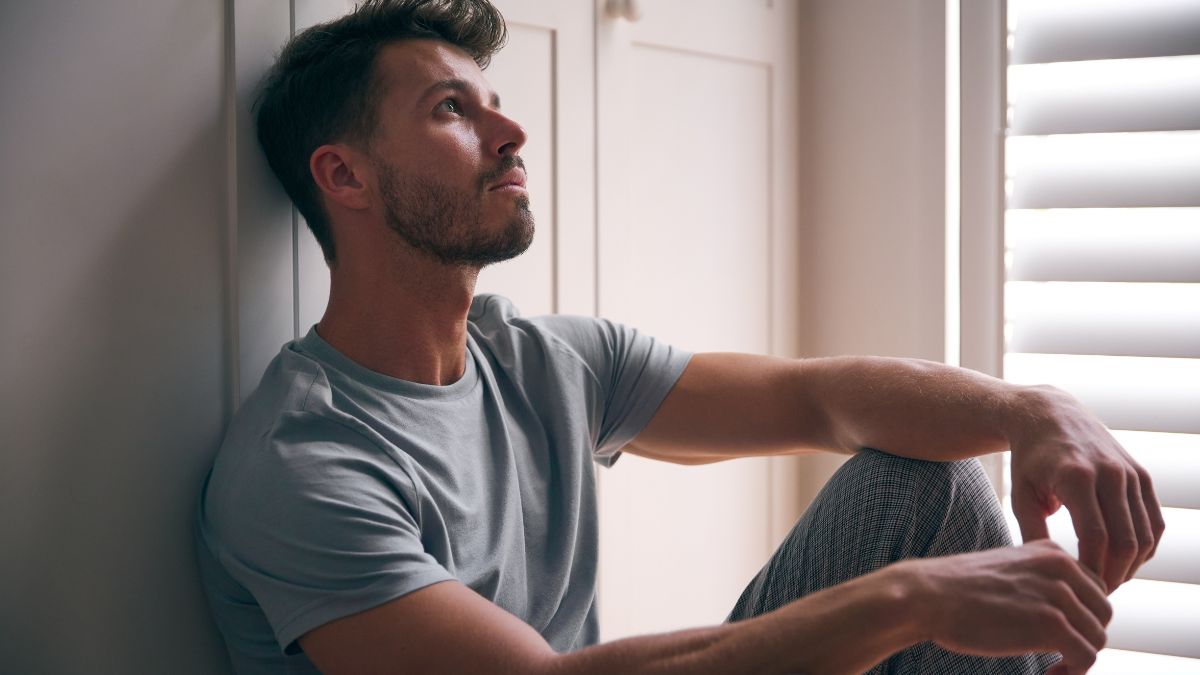 Man sitting on the floor looking to be depressed
