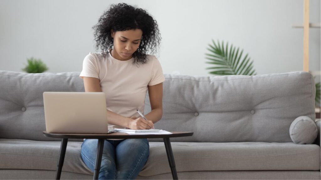 Woman sitting on her couch working on her laptop