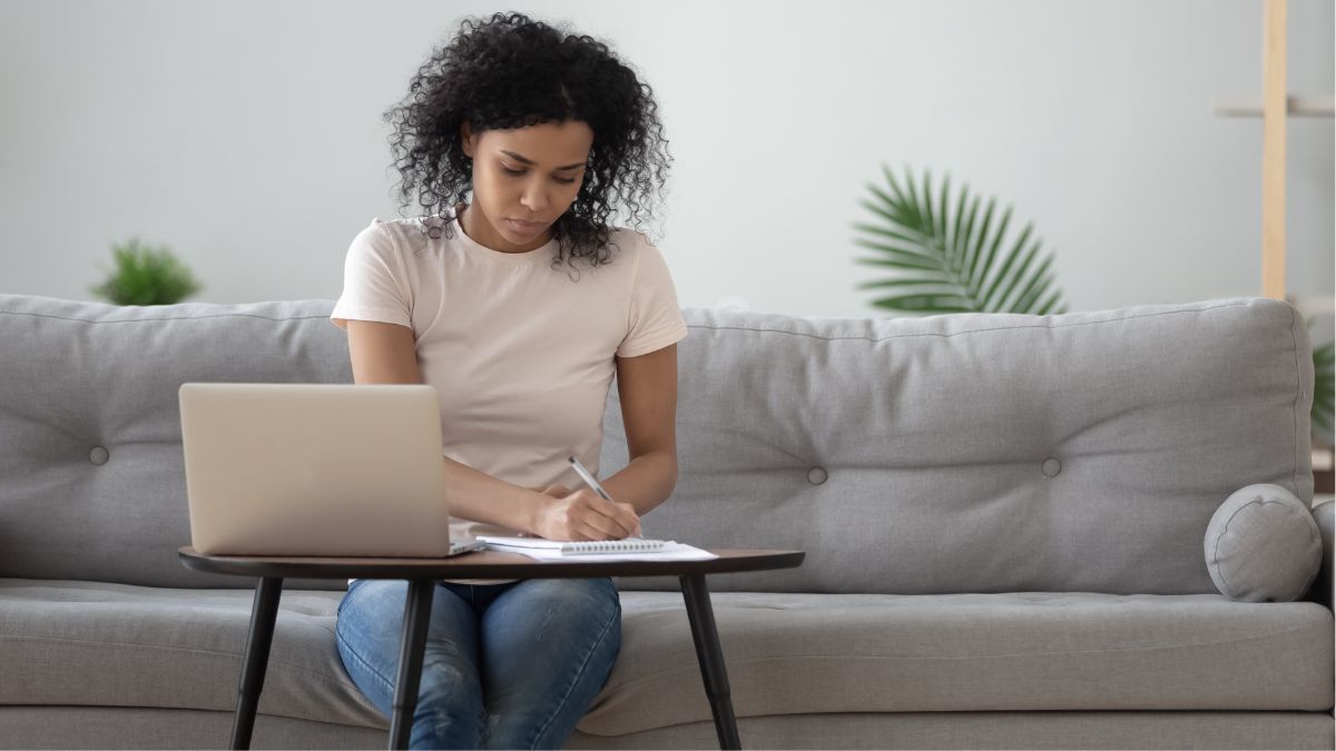 Woman sitting on her couch working on her laptop