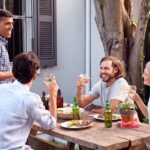 Friends sitting having drinks at a picnic table outside