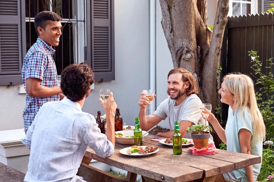 Friends sitting having drinks at a picnic table outside