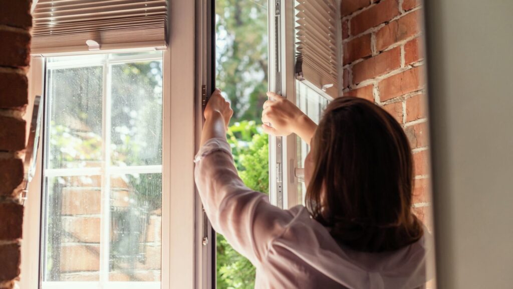 Woman opening windows for fresh air