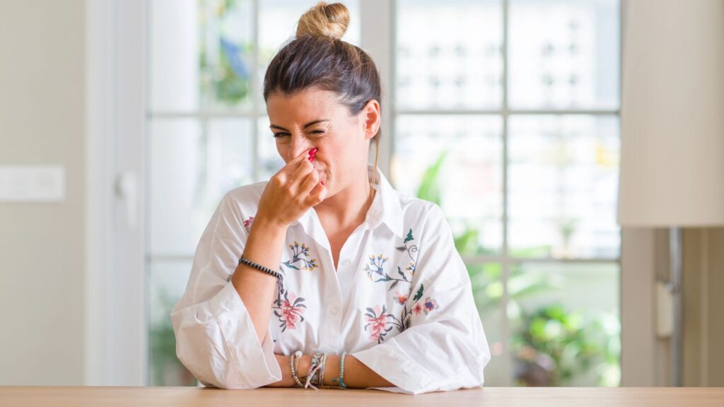 Woman pinching her nose for a bad smell