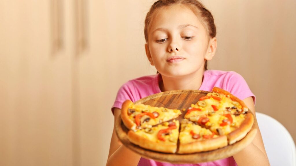 Young girl holding a pizza