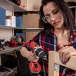 Woman wearing goggles building a wooden frame