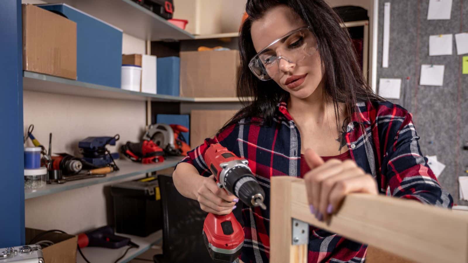 Woman wearing goggles building a wooden frame