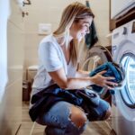 Woman putting laundry into the washer