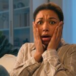 Woman sitting on the couch looking scared