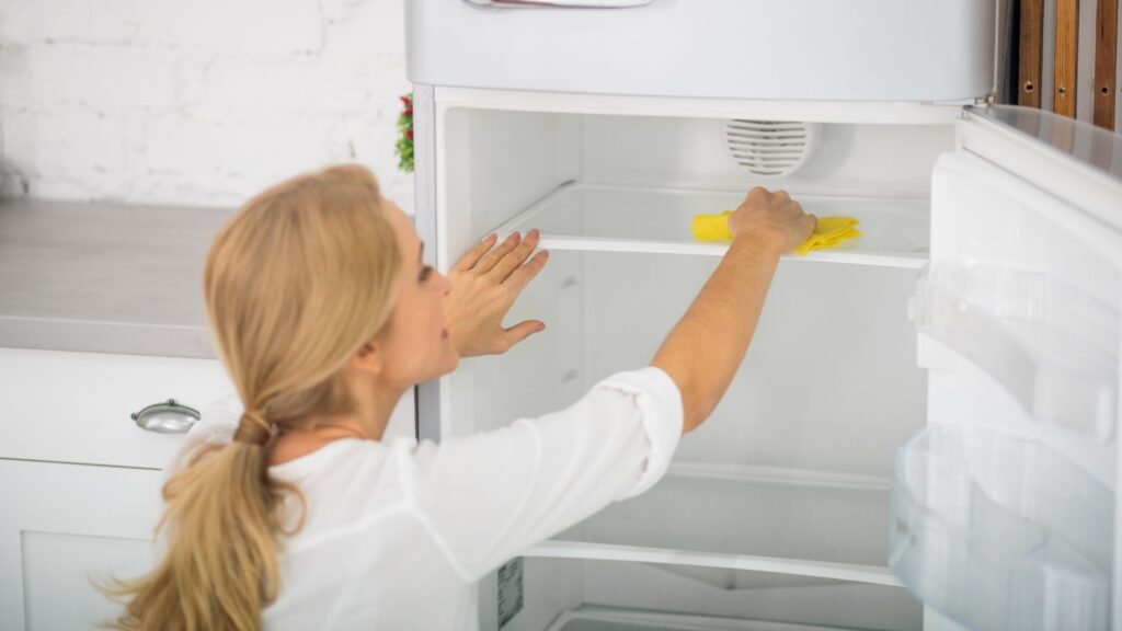 Woman cleaning a refrigerator