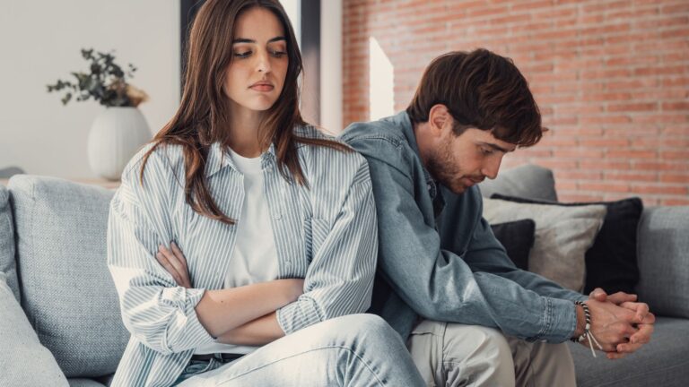 Couple sitting on the couch arguing