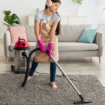 Young girl vacumming the carpet