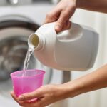 Woman pouring liquid detergent into the cap