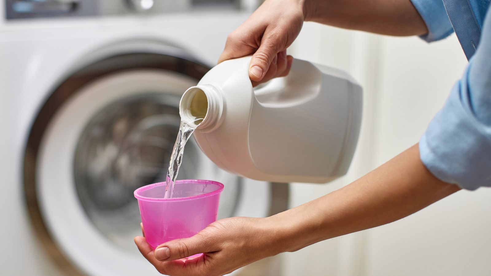 Woman pouring liquid detergent into the cap