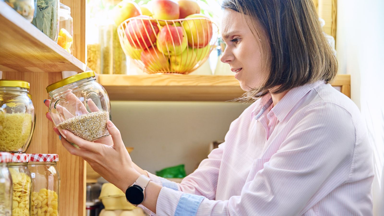 Woman looking at items in her pantry