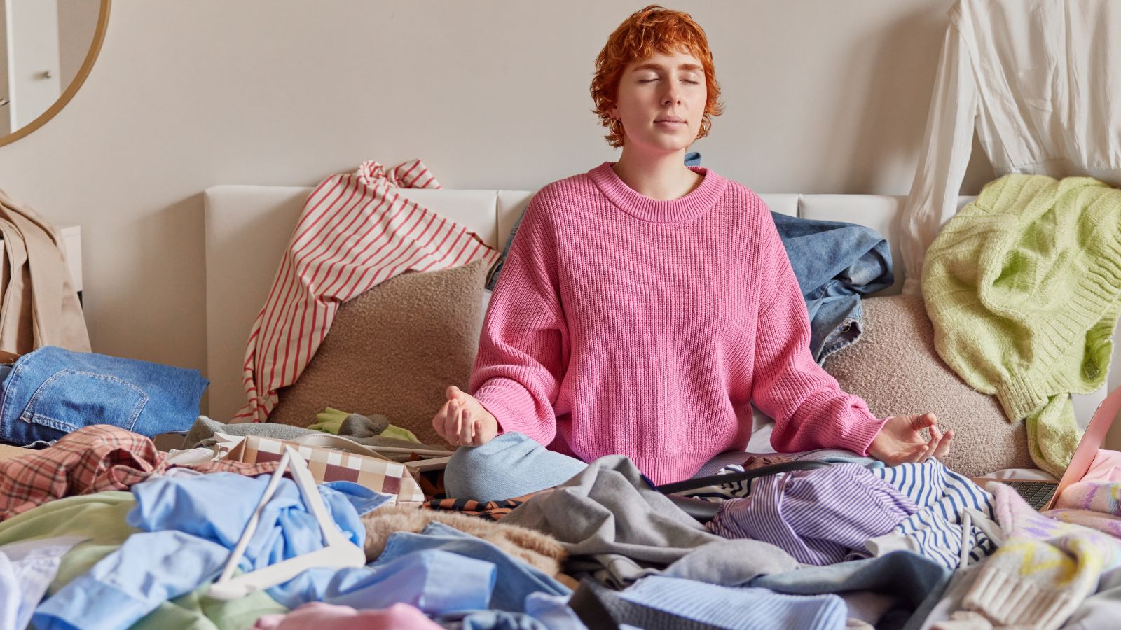 Woman meditating on a messy bed