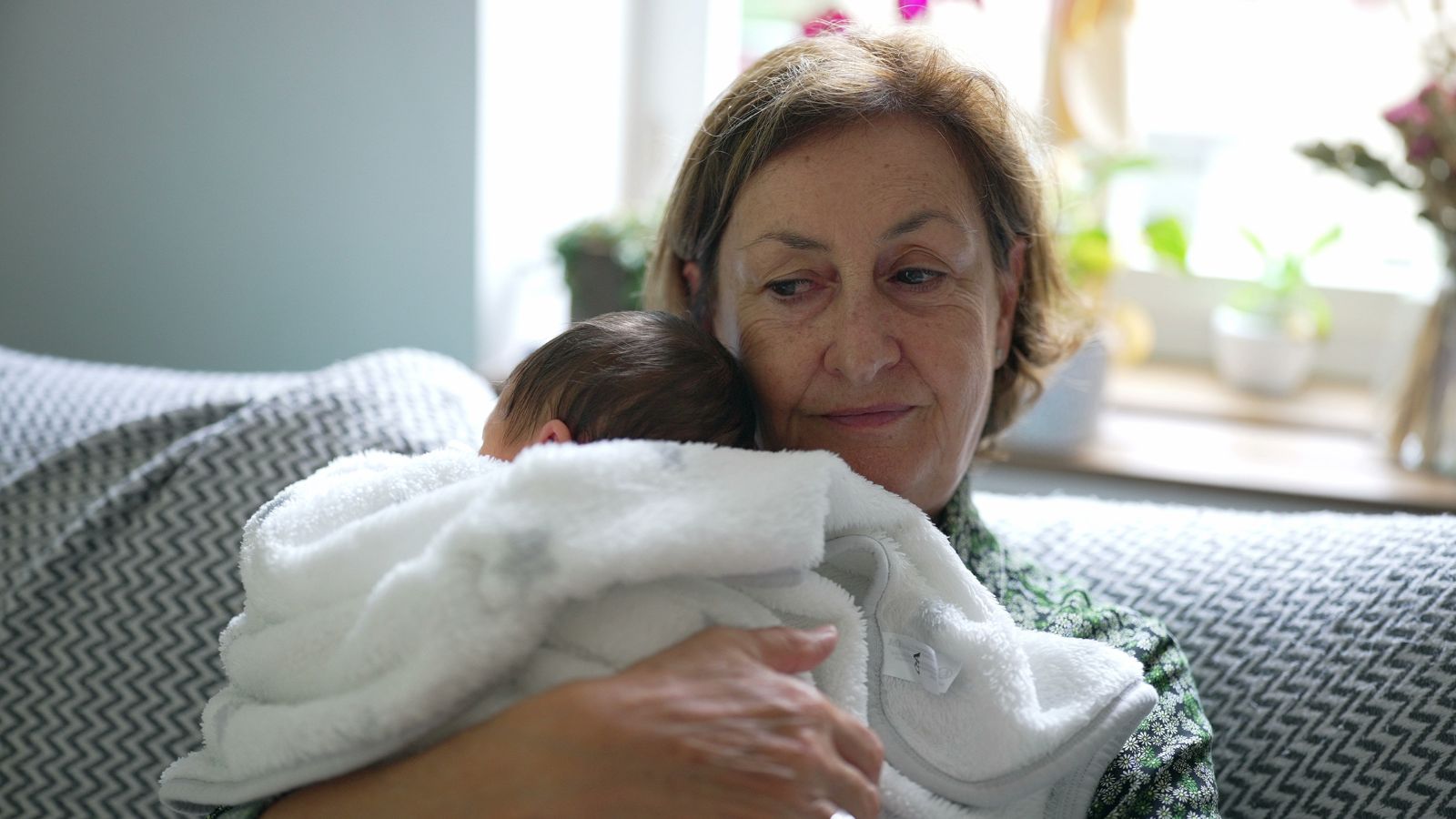 Elderly woman holding a newborn baby