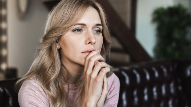 Woman with her hand to her face looking sad