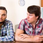 Men sitting at a table looking angry with each other