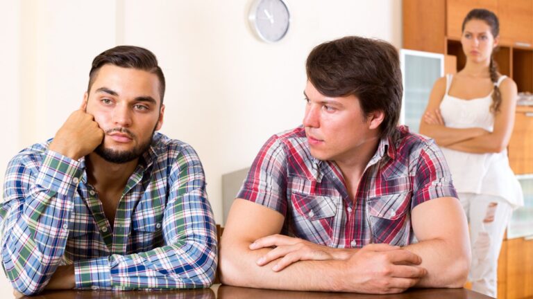 Men sitting at a table looking angry with each other