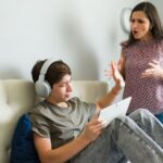 Mother and teenage son arguing in his room