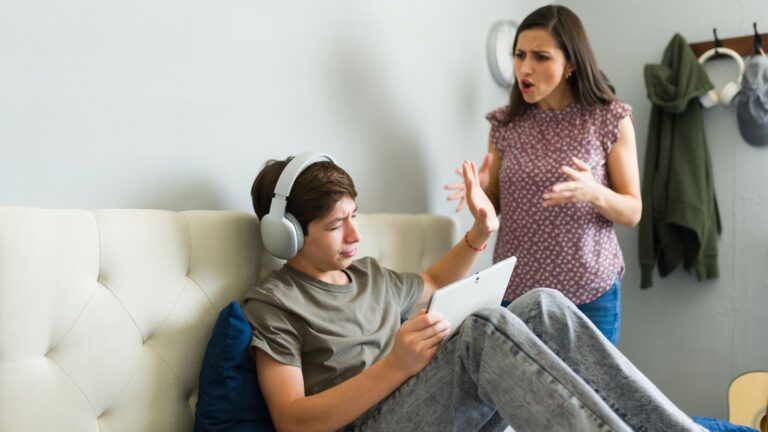 Mother and teenage son arguing in his room