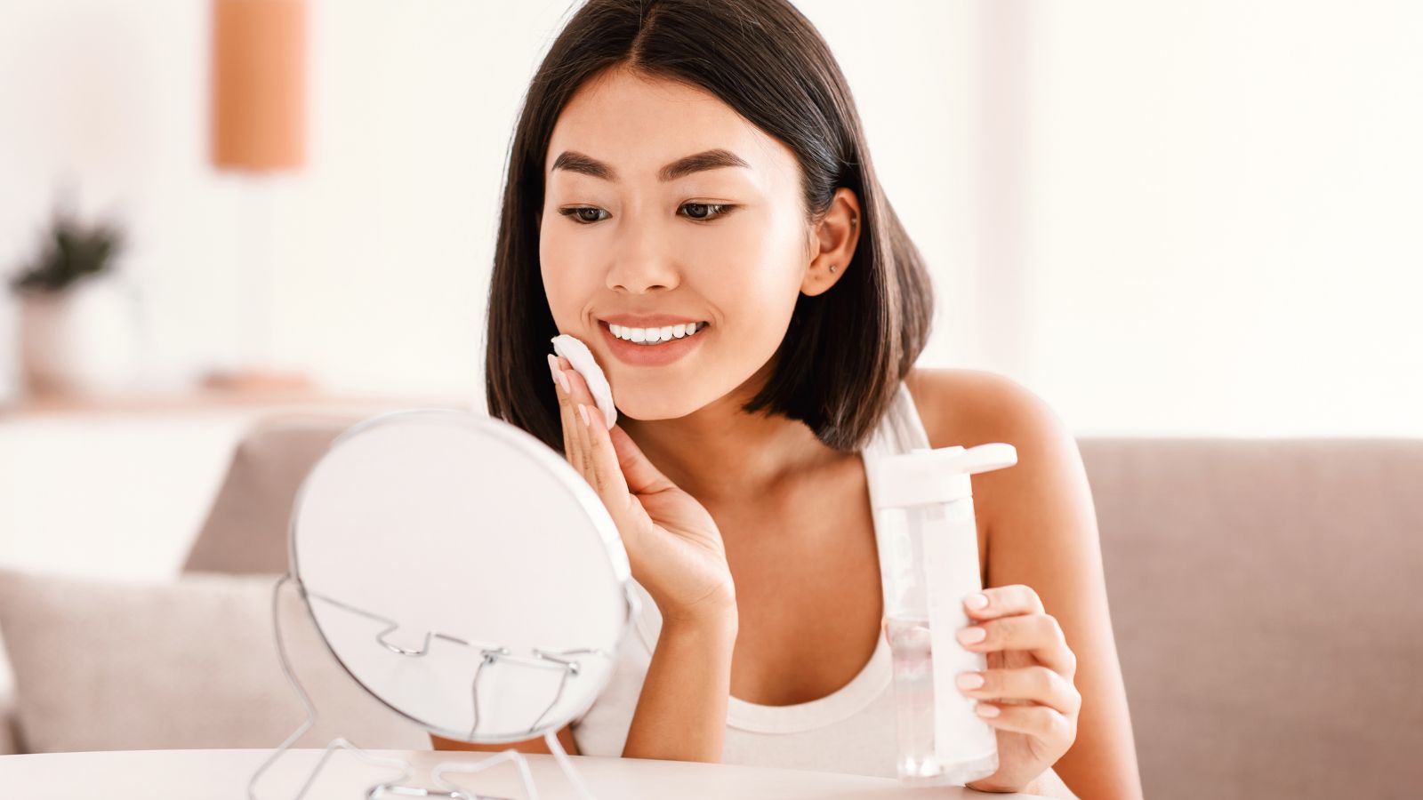 Young woman applying a skincare product to her face