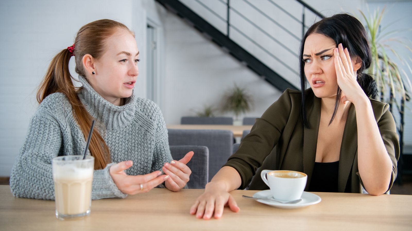 Female friends drinking coffee and arguing