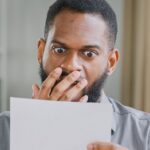 Man looking angry while reading a letter