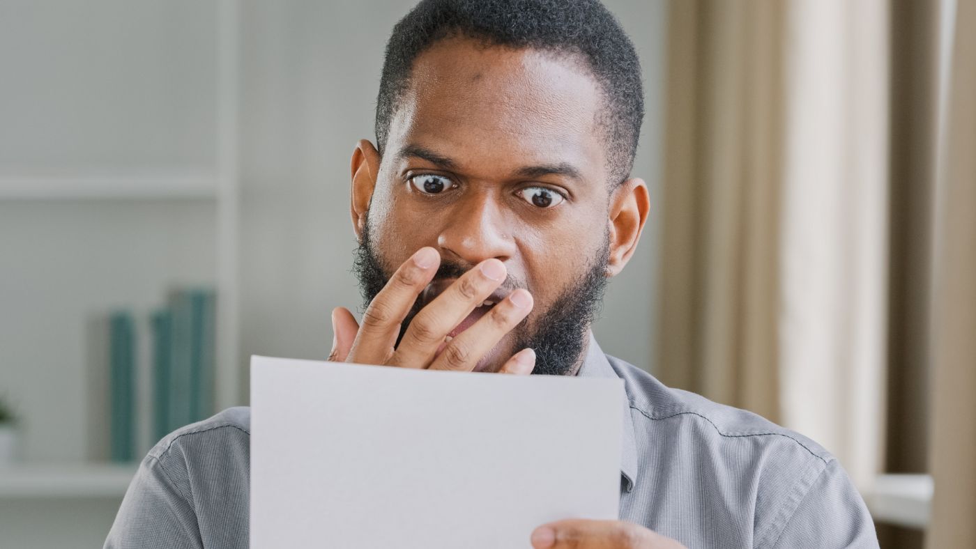 Man looking angry while reading a letter