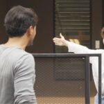 Neighbors seemingly arguing across a fence