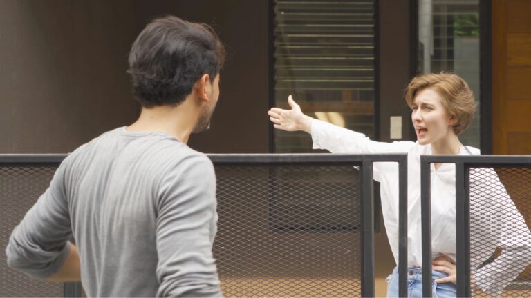 Neighbors seemingly arguing across a fence