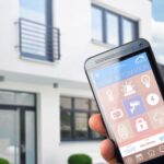 House and hand holding phone