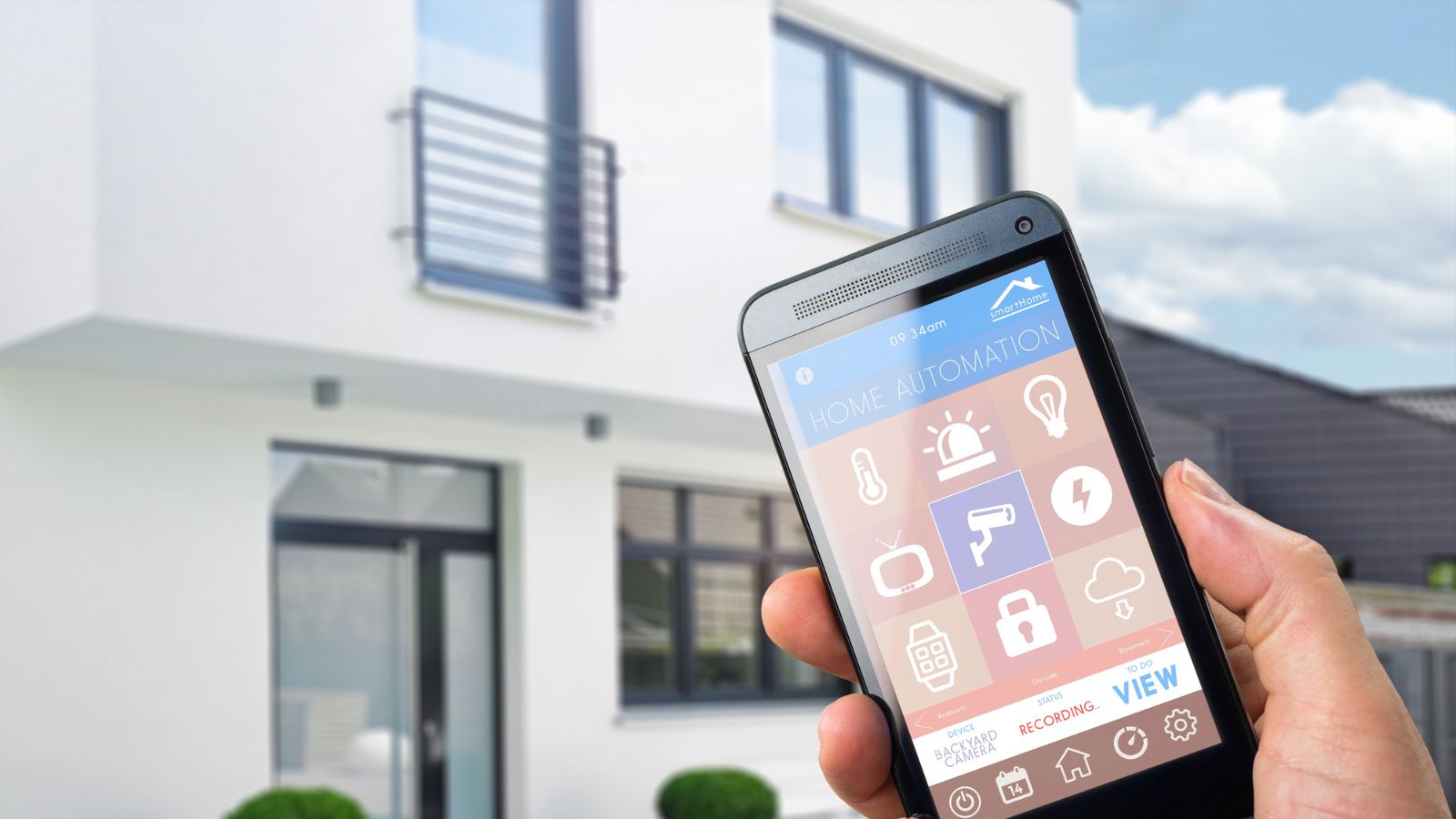 House and hand holding phone
