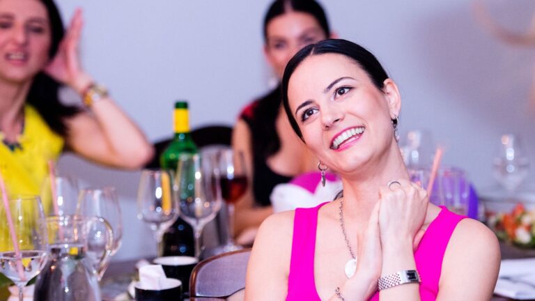 Women sitting at a bar with a bunch of glasses around