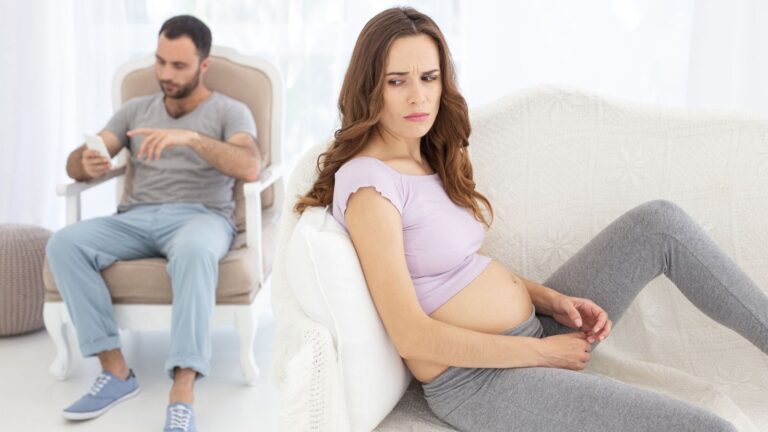Worried pregnant woman with man on his phone