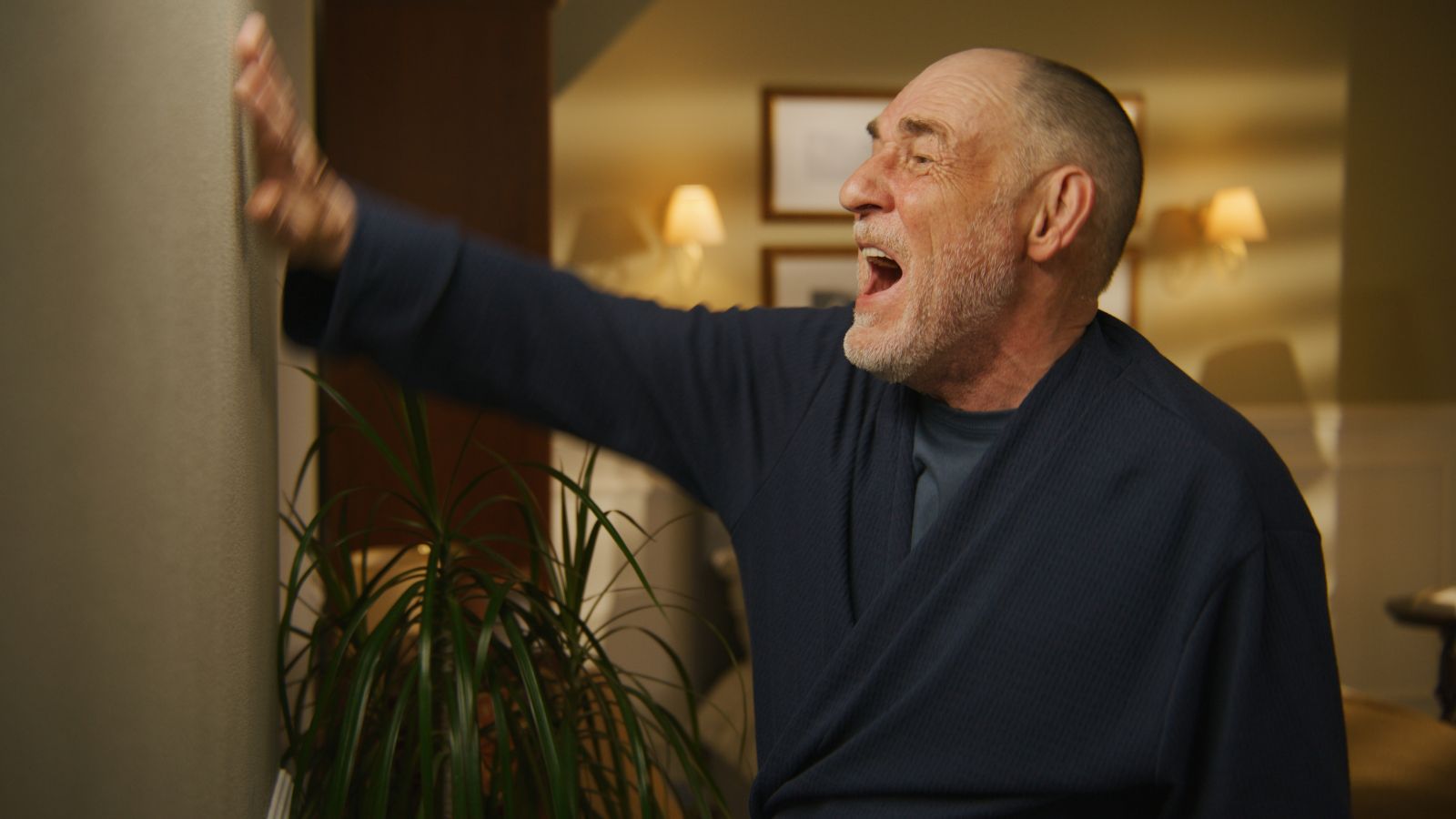 Older man looking angry with his hand on the door