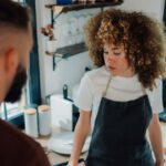 Female barista looking concerned with customer