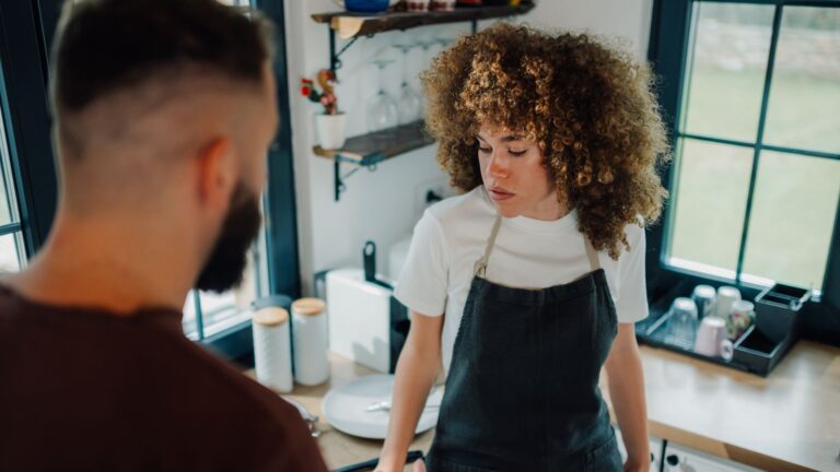Female barista looking concerned with customer