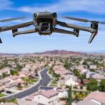 Black drone flying over a neighborhood