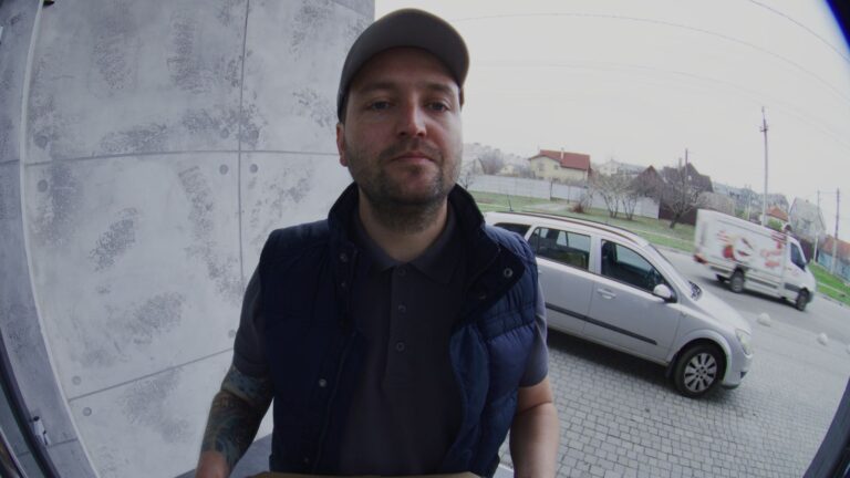 Man in hat standing at door waiting for an answer