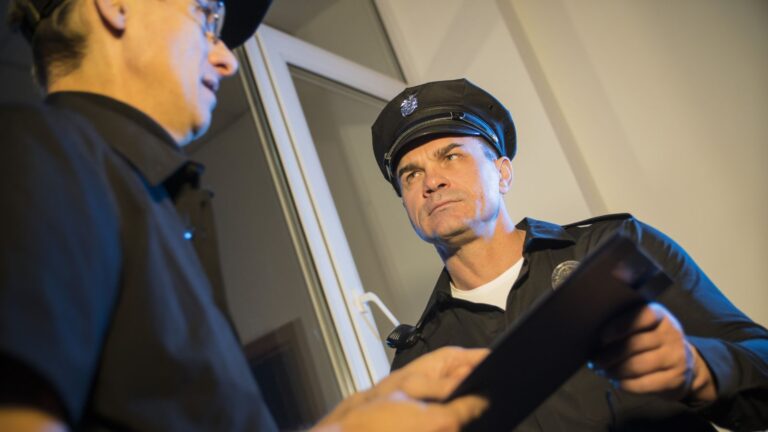Man talking to a cop and they both look annoyed