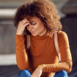 Girl sitting with her hand on her head