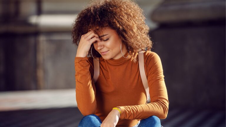 Girl sitting with her hand on her head
