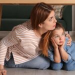 Woman and girl hiding scared under a table