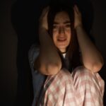 Woman holding her head looking terrified