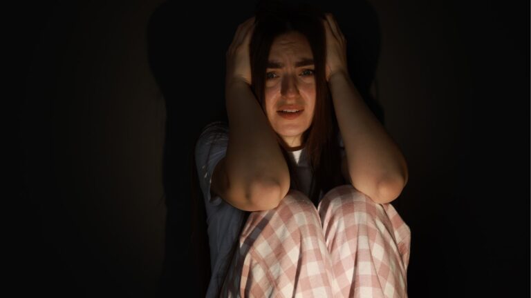 Woman holding her head looking terrified