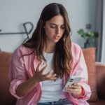 Woman looking upset at her phone