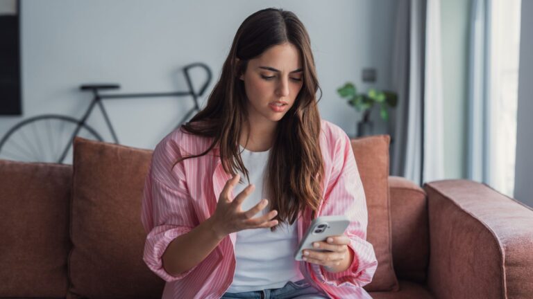 Woman looking upset at her phone
