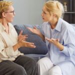 Woman and mother arguing on couch